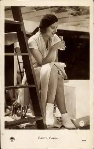 Ak Schauspielerin Greta Garbo, Sitzportrait, Leiter, Glas