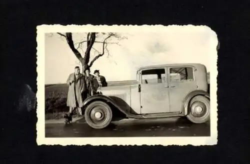 Foto Mann und Frauen vor einem Automobil