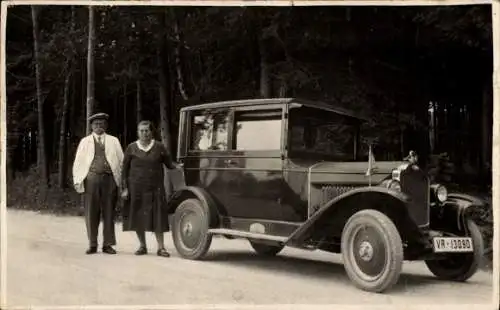 Foto Ak Mann und Frau an einem Automobil auf der Fahrt nach Wien 1931, VR 13090