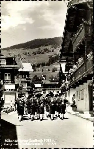 Ak Saalbach in Salzburg, Pinzgauer Trachtenkapelle geht musizierend durch Ort