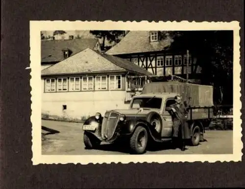 Foto Mann neben einem LKW, Gruppenaufnahme auf einem Feld