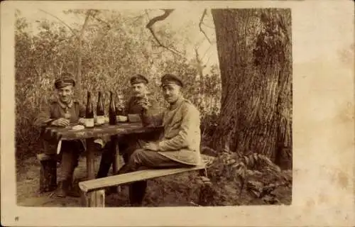 Foto Ak Deutsche Soldaten in Uniformen mit Weinflaschen an einem Tisch