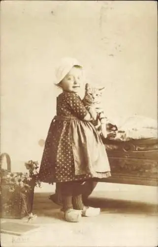 Foto Ak Kind mit Katze, Portrait, Holzschuhe, Korb, Blumen