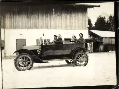 Foto Männer und Frauen in einem Automobil im Schnee