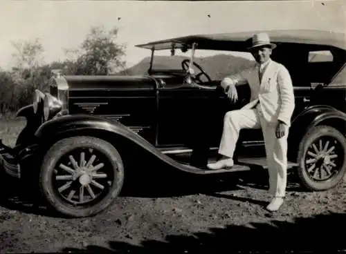 Foto Mann im Anzug neben einem Automobil