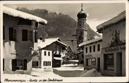 Ak Oberammergau in Oberbayern, Dorfstraße, Kirchturm, Bezirkssparkasse, Winteransicht