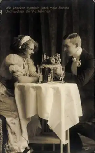 Ak Liebespaar an einem Tisch, Obstschale, Sektflasche