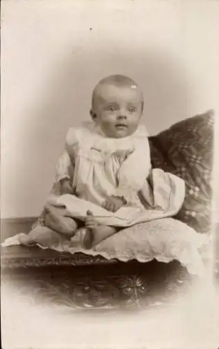 Foto Ak Kinderportrait, Baby auf einem Kissen