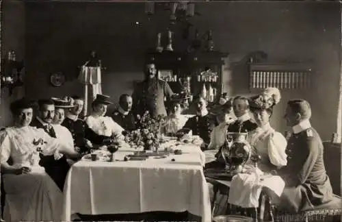 Foto Ak Frauen und Männer am Tisch, Gruppenbild, Blumen, Kaffee