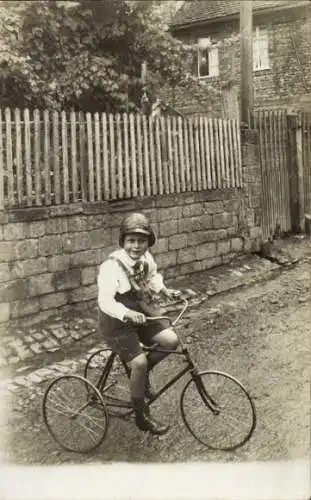 Foto Ak Kind fährt Dreirad, Portrait, Straße, Zaun