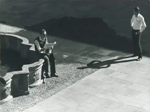 Foto Teilansicht von einem Platz mit Brunnen, Mann liest Zeitung