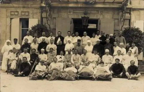 Foto Ak Verwundete Soldaten vor dem Lazarett, Gruppenaufnahme