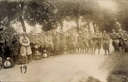 Foto Ak Französische Soldaten mit Marschgepäck auf einer Straße