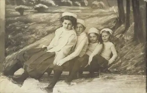 Foto Ak Vier Kinder auf einem Schlitten, Portrait