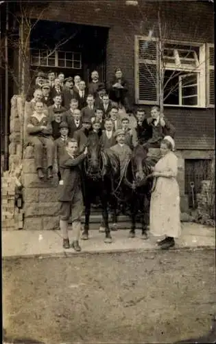 Foto Ak Gruppenaufnahme von Männern und Frauen vor einem Gebäude, Pferde