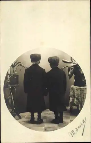 Foto Ak Zwei Jungen in Mänteln und mit Mützen, Rückansicht