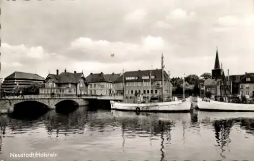 Ak Neustadt in Holstein, Blick über Schiffe im Hafen und eine Brücke zum Ort