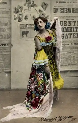 Ak Frau in spanischer Tracht vor einer Wand mit Zeitungsausschnitten