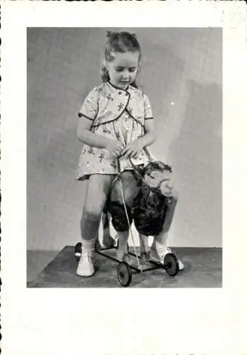 Foto Ak Kinderportrait, Mädchen auf einem Kamel auf Rollen, Reittier