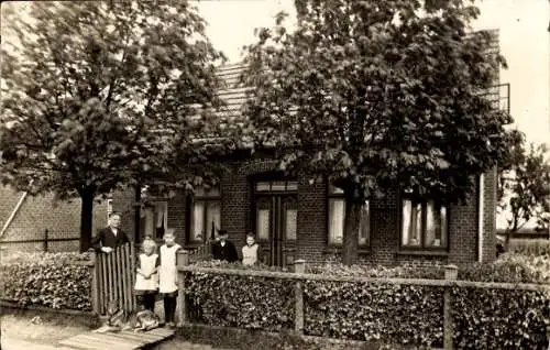 Foto Ak Familie steht am Zaun, Backsteinhaus