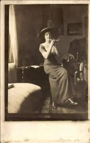 Foto Ak Frau zündet sich eine Zigarette an, Portrait, Hut