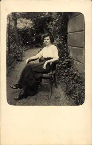 Foto Ak Junge Frau sitzt auf dem Stuhl, Portrait