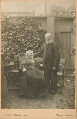 Kabinett Foto Schleswig an der Schlei, Älteres Paar im Garten, um 1906