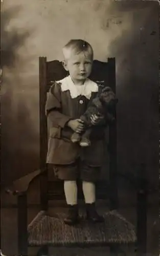 Foto Ak Kind-Portrait, Junge mit Teddy, Stuhl