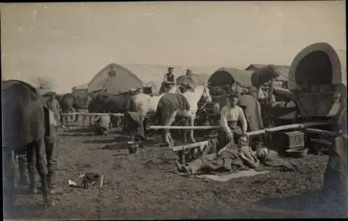 Foto Ak Deutsche Soldaten in Uniformen bei der Rast, Pferde, Planwagen