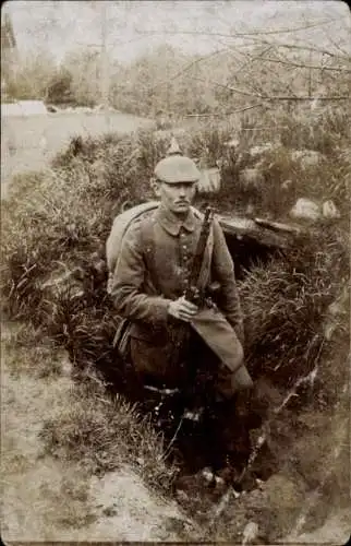 Foto Ak Deutscher Soldat in Uniform in einem Graben