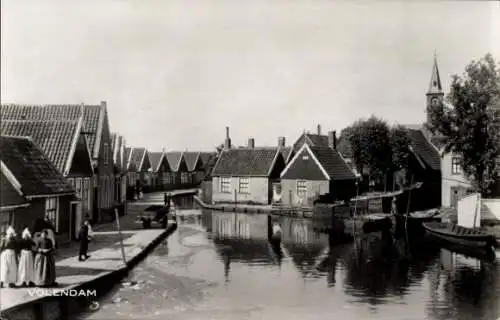 Ak Edam Volendam Nordholland, Flusspartie im Ort, Kirchturm, Frauen in Tracht