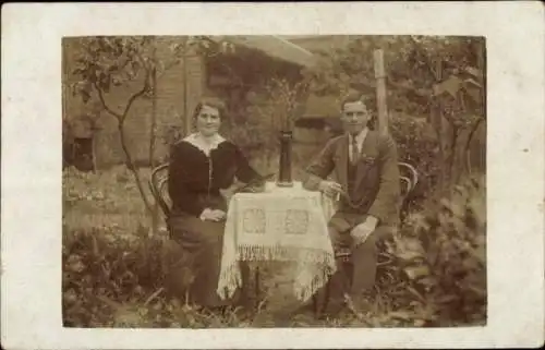 Foto Ak Mann und Frau an einem Tisch im Garten, Portrait