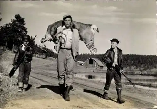 Ak Schauspieler Robert Mitchum, Portrait mit erschossenem Eber, zwei Jungen mit Gewehren