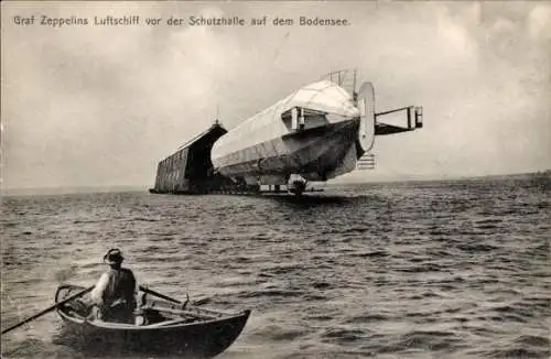 Ak Graf Zeppelin's Luftschiff vor der Schutzhalle auf dem Bodensee, Ruderboot