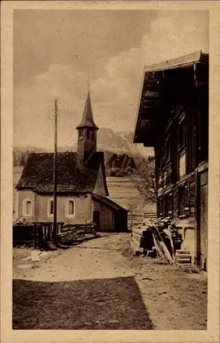 Ak Kornau Oberstdorf im Oberallgäu, Stadtansicht, Holz vor der Hütte, Glockenturm