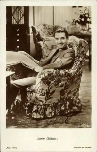 Ak Schauspieler John Gilbert, Portrait, Sessel