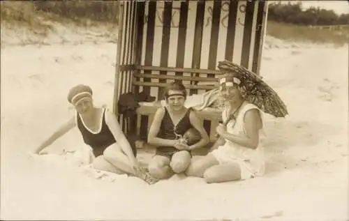 Foto Ak Drei Frauen am Strand, Badeanzug, Strandkorb, Sonnenschirm