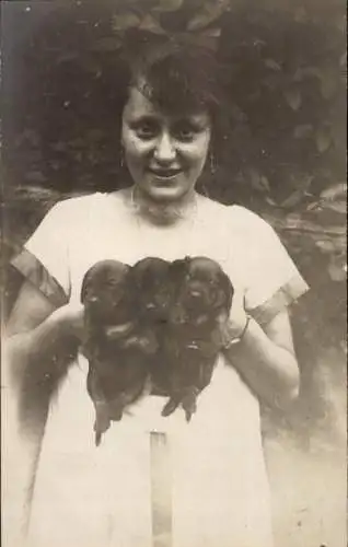 Foto Ak Junge Frau hält drei kleine Dackel, Hundewelpen