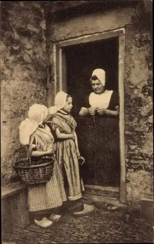 Ak Zeeland, Mädchen in traditioneller niederländischer Tracht am Hauseingang