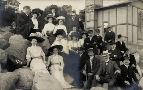 Foto Ak Touristen, Gruppenbild, Felsen, Haus