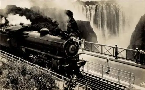 Ak Rhodesien Simbabwe, ein Zug der Rhodesian Railways, der die Victoria Falls Bridge überquert