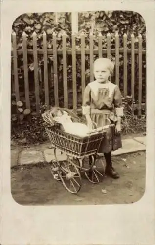 Foto Ak Mädchen mit Puppenwagen, Puppe, Zaun