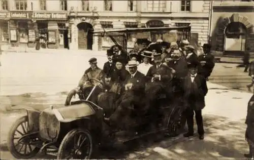 Foto Ak München, vollbesetztes Automobil auf dem Lenbachplatz, Juli 1910, Geschäft J. Schweitzer