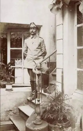 Foto Ak Soldat in Uniform, Porträt, Wohnhaus, Pflanzen