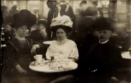 Foto Ak Zwei Frauen und Mann am Tisch, Tassen, Kaffee, Tee