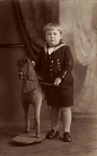 Foto Dicker Junge im Matrosenanzug mit Schaukelpferd, Portrait