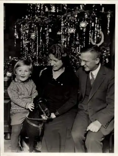 Foto Familie vorm Weihnachtsbaum, Kind auf einem Schaukelpferd, Portrait