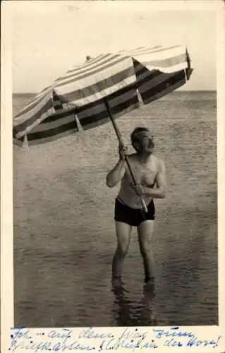 Foto Ak Mann in Badehose mit Sonnenschirm, Auf dem Weg zum Briefkasten