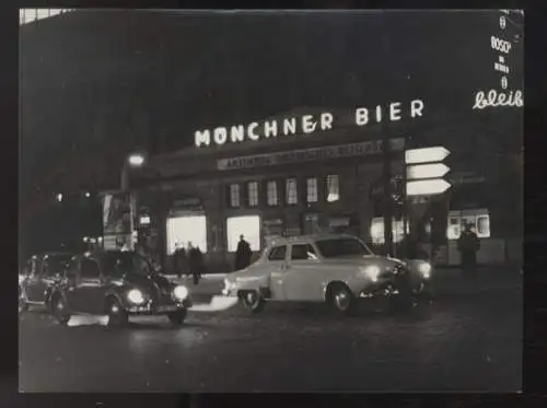 Fotografie nächtliches Straßenbild mit Leuchtreklame "Münchner Bier", Autos, Litfaßsäule, um 1950