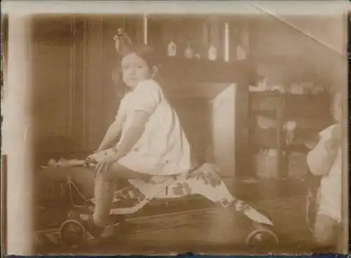 Foto Mädchen auf einem Vierrad in Pferdeform, Portrait